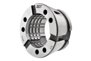 Närbild av en cylindrisk mekanisk komponent med invändiga spår och hål, märkta "0DT" och "G5" i svart text på en vit och metallisk yta.