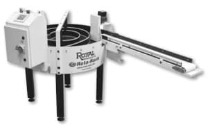 Ett Royal Products Rota-Rack, en automatiserad reservdelsackumulator med en spiraldesign och ett transportband, uppsatt på svarta ben.